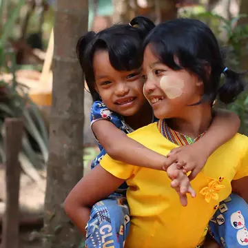 World Vision Patenkinder aus Asien: Mädchen trägt ihre Schwester auf dem Rücken