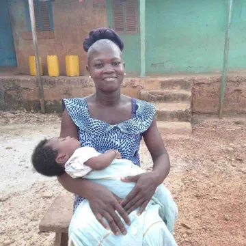 Portia aus Diaso hält ihr Baby auf dem Arm