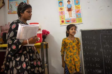 Mädchen mit Lehrerin vor der Klasse in Indien
