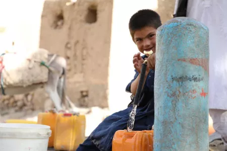 Afghanischer Junge an Brunnen
