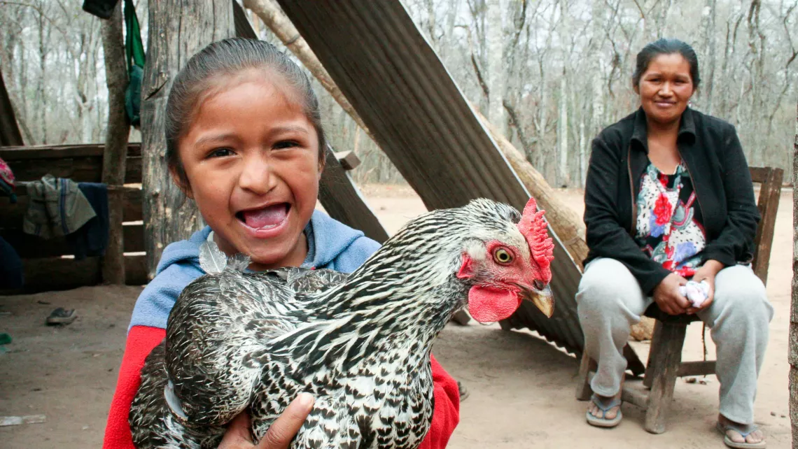 Kleines Mädchen hält ein Huhn in Los Chocos Bolivien World Vision