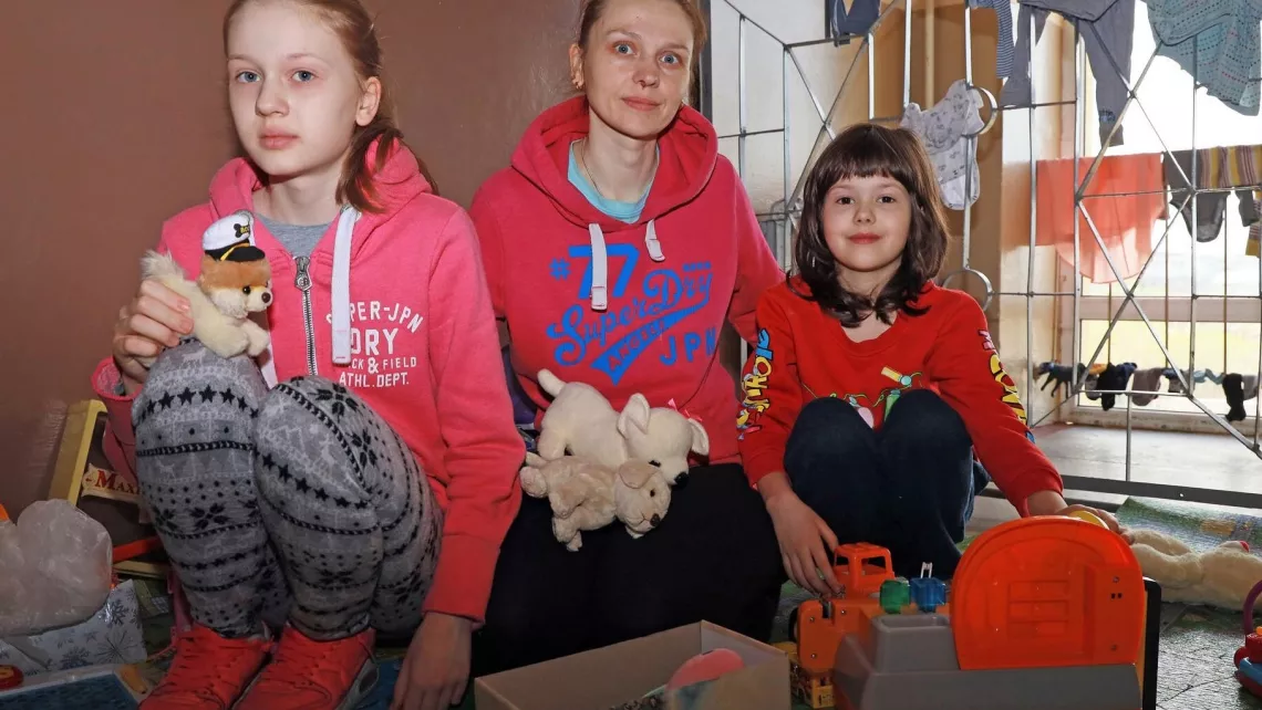 Eine ukrainische Mutter mit Töchtern in einer von World Vision unterstützten Notunterkunft