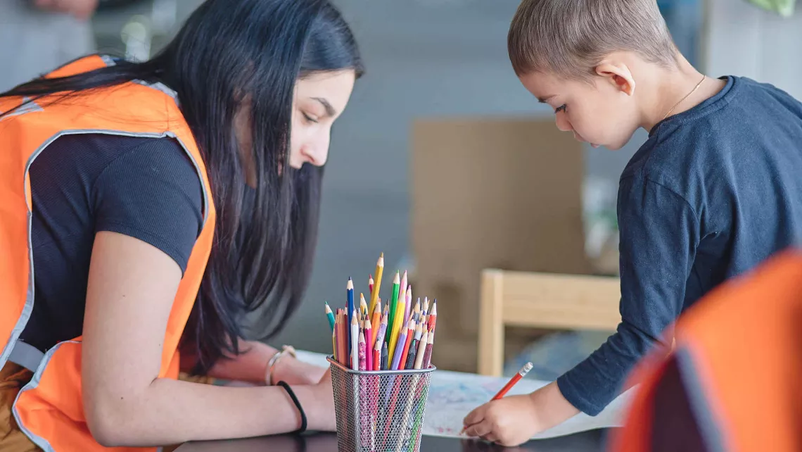 Eine World Vision Mitarbeiterin kümmert sich um einen ukrainischen Jungen.