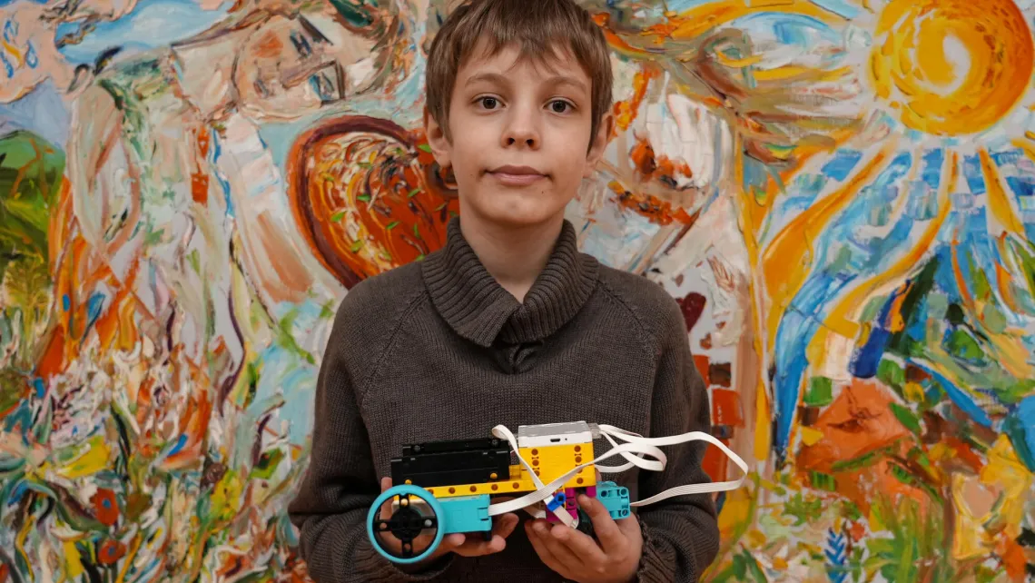 Junge vor Bild mit Sonne in einem kinderfreundlichen Raum in der Ukraine