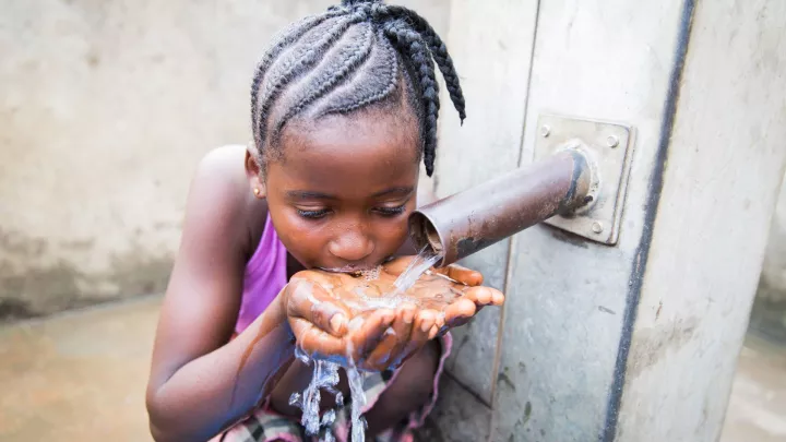 Patenkind Isata trinkt sauberes Wasser im Dorf.