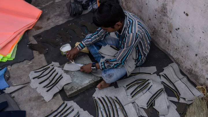 Kinderarbeiter Karan aus Bangladesch klebt Schuhteile zusammen