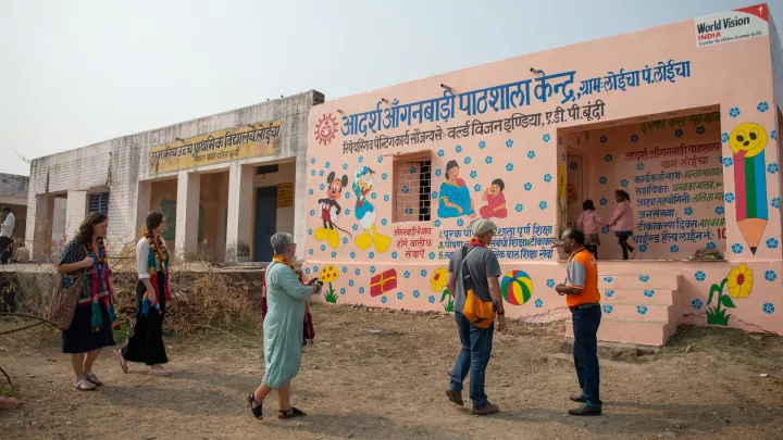 Paten vor einem World Vision Gebäude in Indien