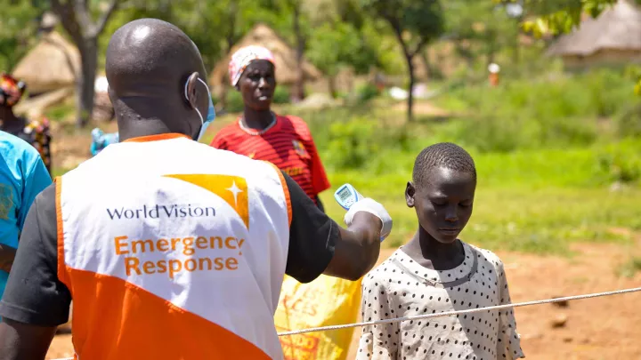 World Vision Mitarbeiter misst die Körpertemperatur