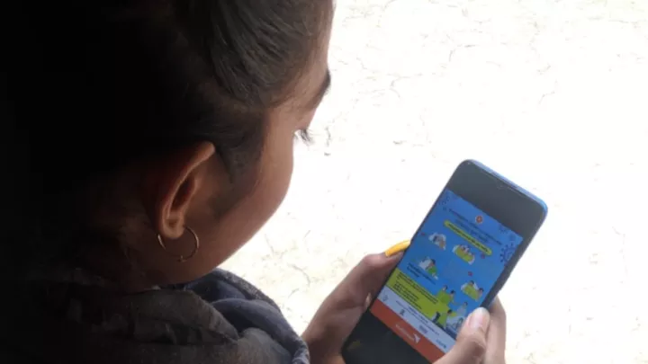 Farzana aus Bangladesch steht via Handy mit anderen Kindern in Kontakt