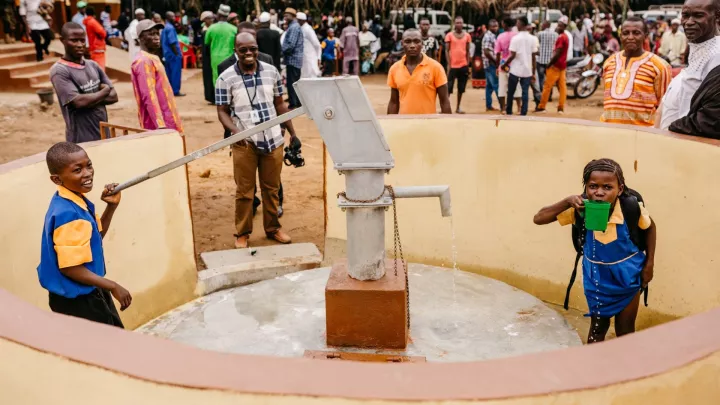 Schulkinder trinken Wasser aus ihrem neuen Brunnen in Sierra Leone.