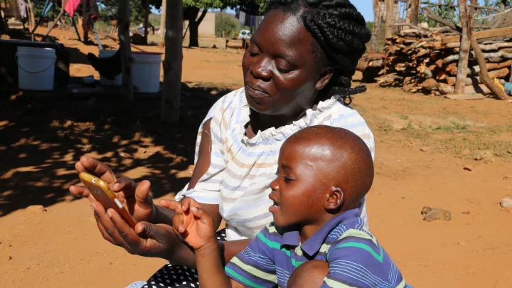 Mutter und Sohn machen zusammen Hausaufgaben am Handy