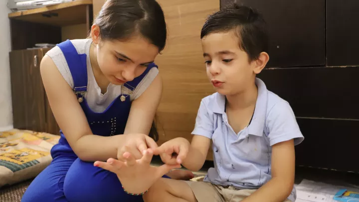 Dem Schulanfänger Hassan hilft seine große Schwester Lariissa beim Zählen und Rechnen. 