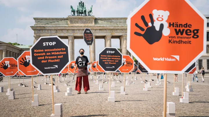Aktionsteilnehmerin mit T-Shirt "Act" am Brandenburger Tor