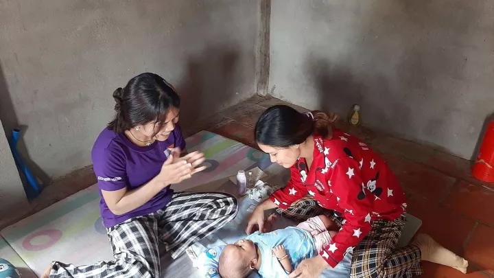 Gesundheitshelferin bei einem Hausbesuch bei einer Mutter und ihrem Baby