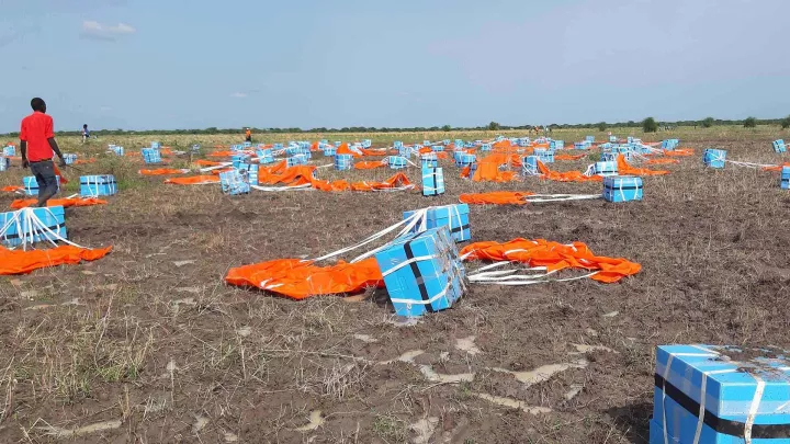 Helferinnen und Helfer müssen nach der Landung sicherstellen, dass die Nahrungsmittelpakete bei den Richtigen ankommen.