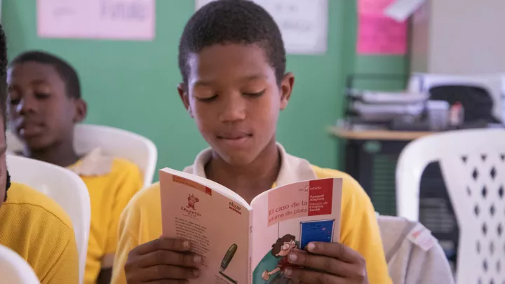 Junge in einem Leseclub in der Dominikanischen Republik