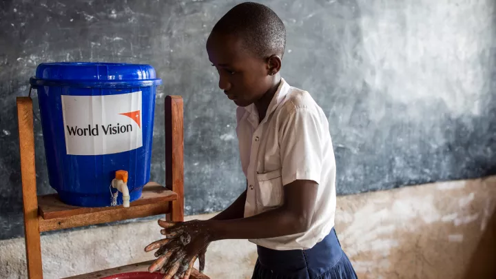 Junge wäscht die Hände an einer Handwaschstation