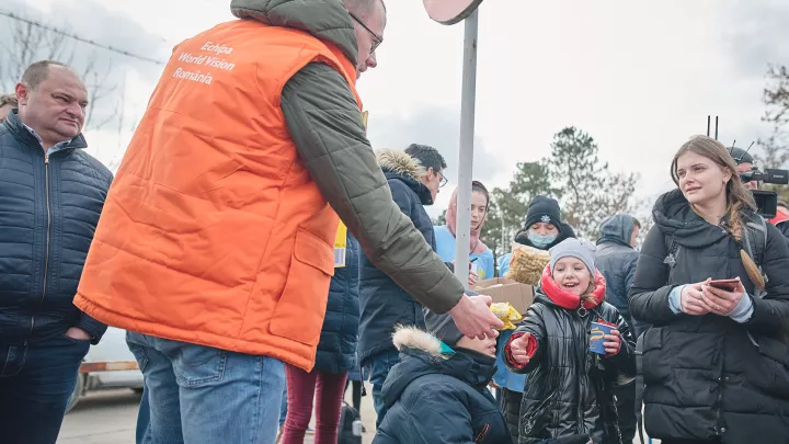 World Vision-Mitarbeiter in Rumänien übergibt Snacks an Kinder aus der Ukraine.