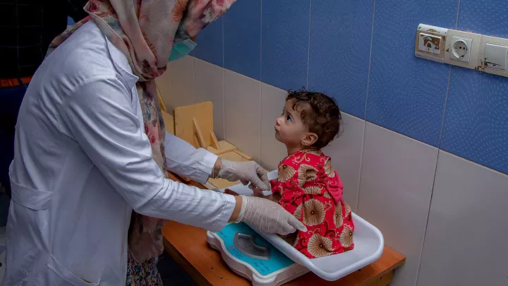 afghanisches Kind wird von einer Krankenschwester untersucht