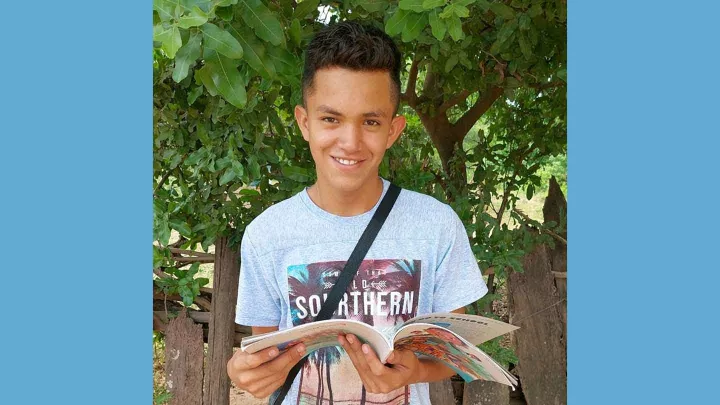 World Vision Patenkind mit Lesebuch