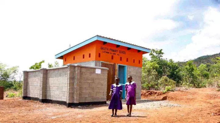 Mädchen vor einer neu gebauten Latrine