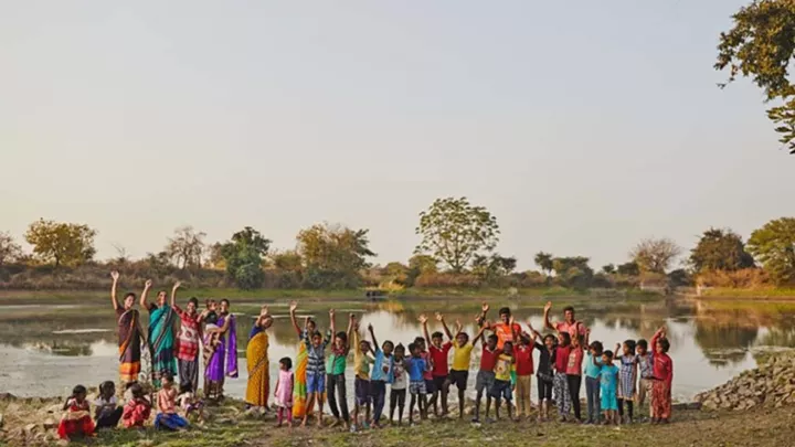 Kinder in Indien winken in die Kamera