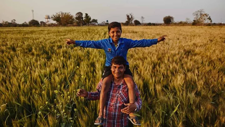 Vater mit Kind in seinem Feld in Indien