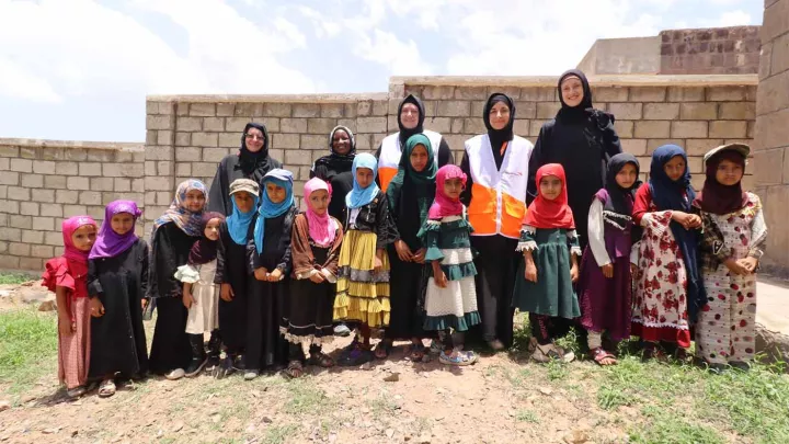 Schulklasse mit Lehrerinnen und World Vision Mitarbeitenden im Jemen