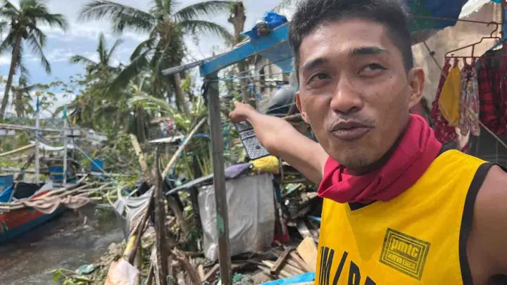 Mann vor der Zerstörung, die ein Wirbelsturm auf den Philippinen angerichtet hat