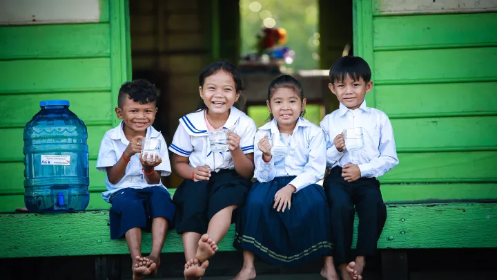 Kinder freuen sich über Wasserfilter und sauberes Trinkwasser