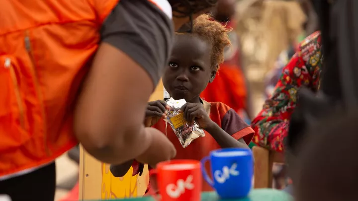 World Vision Mitarbeiter gibt Kind Aufbaunahrung