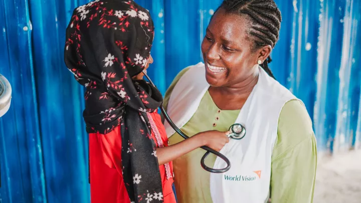 in geflüchtetes Mädchen aus dem Sudan spielt Ärztin mit Hebamme Paula Atimango.