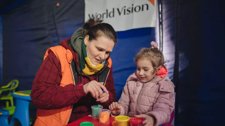 WV Mitarbeiterin spielt mit einem Flüchtlingskind