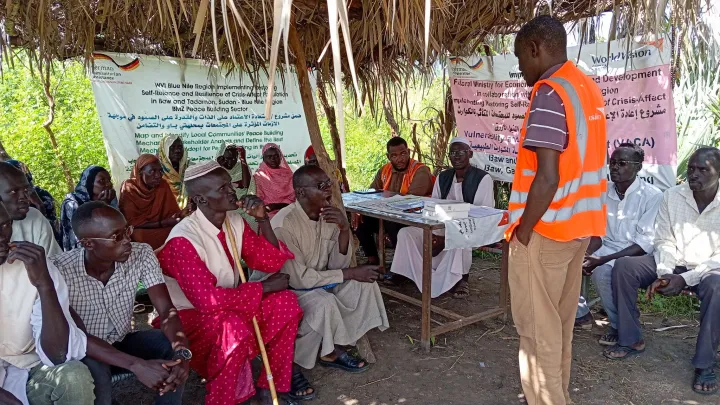 Diskussion mit Männern im Sudan zu Frieden und Kinderschutz
