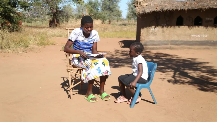 Ein Kind aus Malawi wird von einer Jugendichen zu seinen Erfahrungen mit Schulmahlzeiten befragt