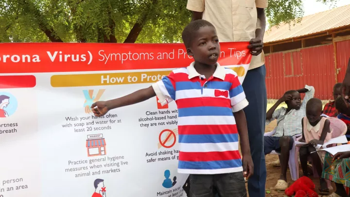 Ein Junge im Südsudan erklärt Verhaltensregeln im Kampf gegen Corona