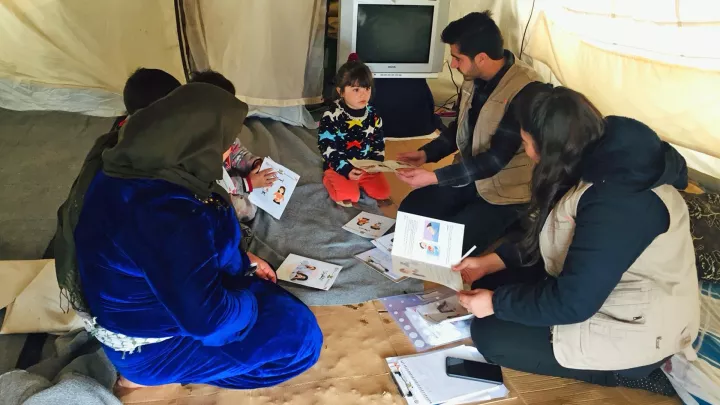 Menschen lernen gemeinsam in einem Flüchtlingscamp im Irak wie sie sich um ihre Gesundheit kümmern können