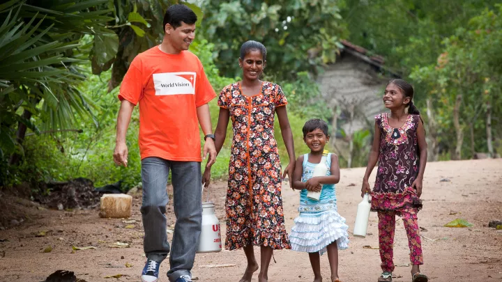 World Vision Mitarbeiterin mit einer Familie aus Sri Lanka