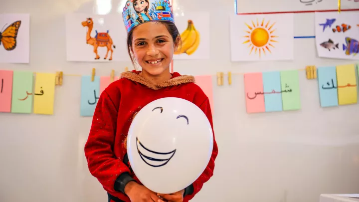 World Vision-Bildungsprojekt: Schülerin in Syrien mit lachendem Ballon