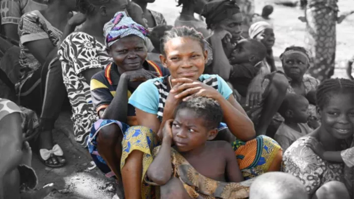 Zwei Frauen und ein Kind mit ihrer Gemeinde in Zentralafrika