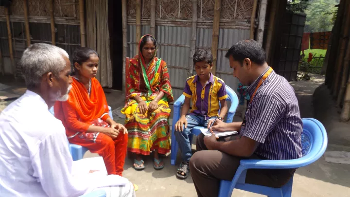 Jesmins Familie im Gespräch mit World Vision-Mitarbeiter