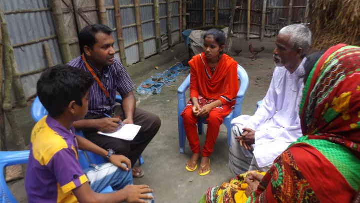 Jesmins Familie im Gespräch mit World Vision-Mitarbeiter