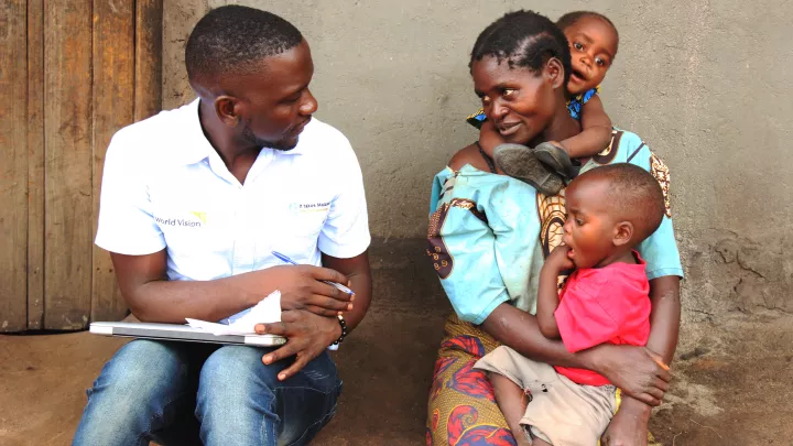 World Vision Mitarbeiter Charles Kabena im Gespräch mit der Familie