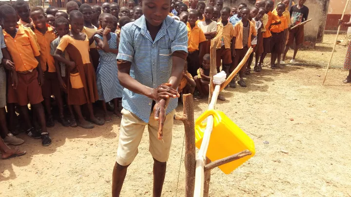 Hygiene lernen: Ein Schüler aus Ghana demonstriert wie man sich richtig die Hände wäscht