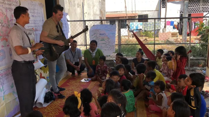 Musiker Jon Bauer spielt vor Kindern Gitarre