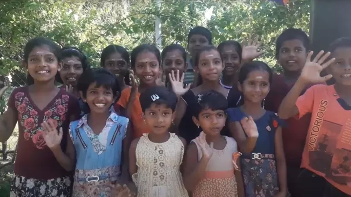 Die Kinder winken in die Kamera