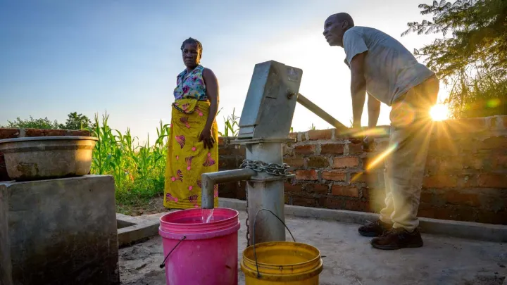 Menschen an einem Wasserbrunnen in Sambia