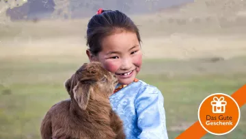 Mädchen aus der Mongolei mit Schaf auf dem Arm