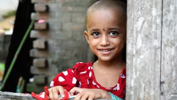 Mädchen aus Bangladesch lehnt an einer Tür
