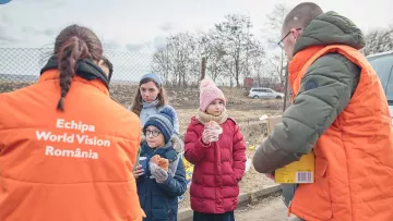 Mitarbeiter helfen Flüchtlingskindern